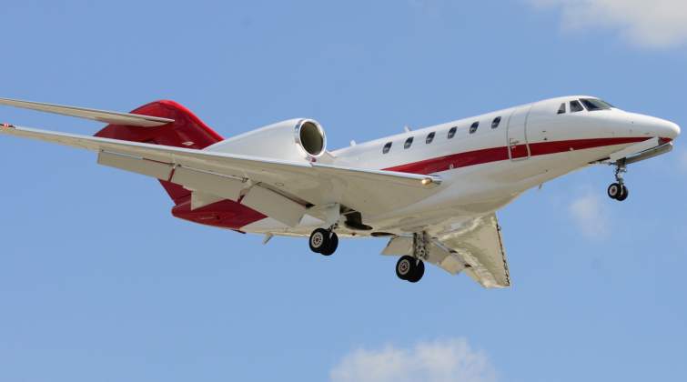 This beautiful red and white Citation X is captured on camera during a landing as it descended to th
